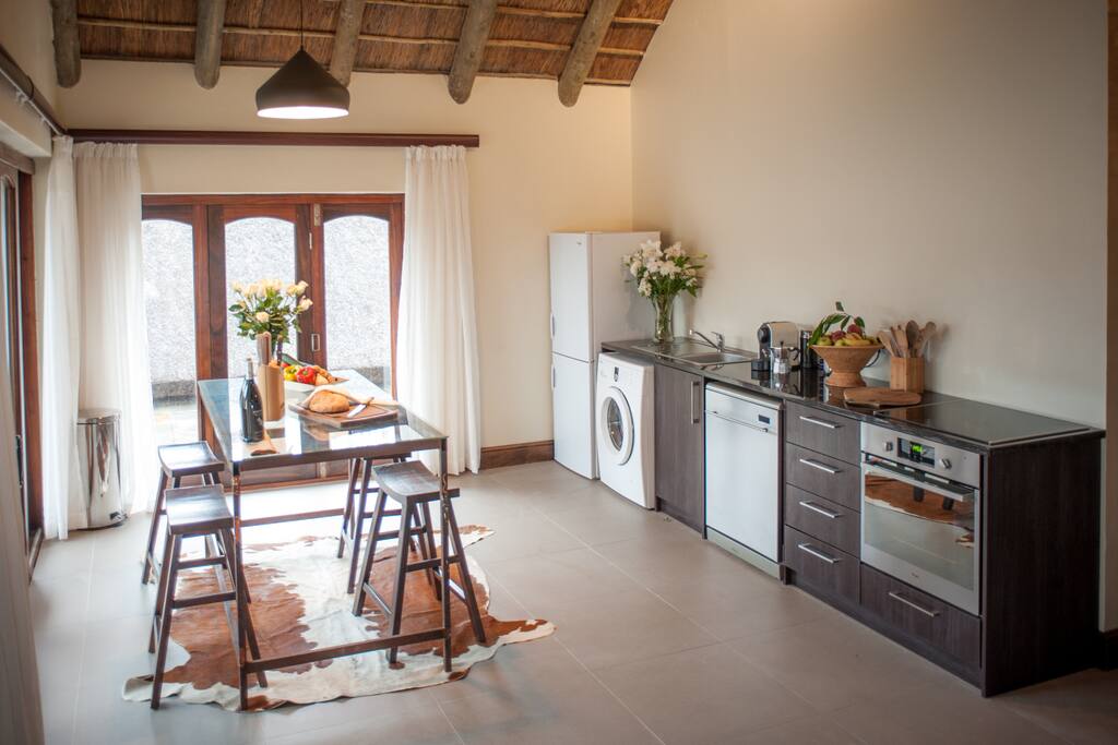 New kitchen with fridge, freezer, stove, Nespresso machine, Espresso machine, Washing machine and dining table. Opens up to private patio.