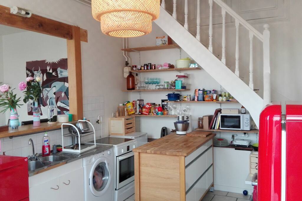 La cuisine équipée : frigo, congélateur, machine à laver, cuisinière et lave-vaisselle.