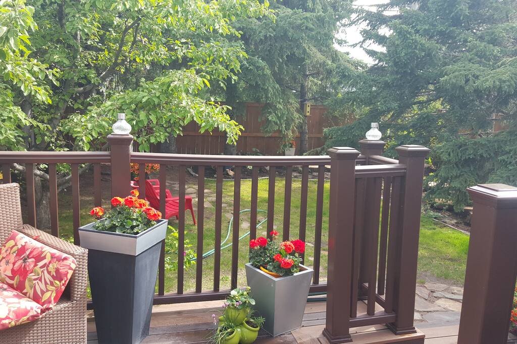 Deck backing on to lower patio and backyard with barbeque