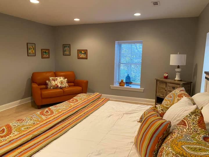 Dormitorio principal del tercer piso con cama tamaño king y sillón de dos plazas