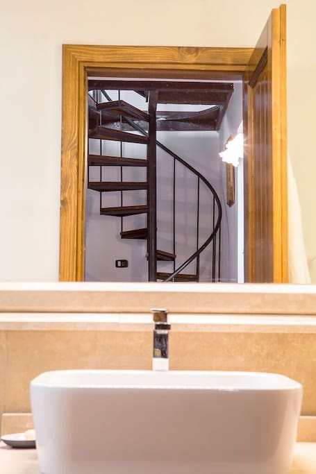 A reflection of the spiral staircase from the Italian marble bathroom.