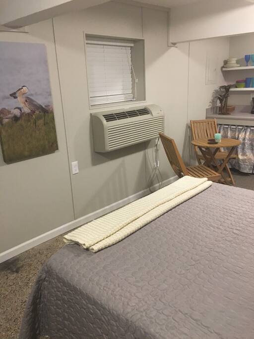Queen bed, AC unit, and seating