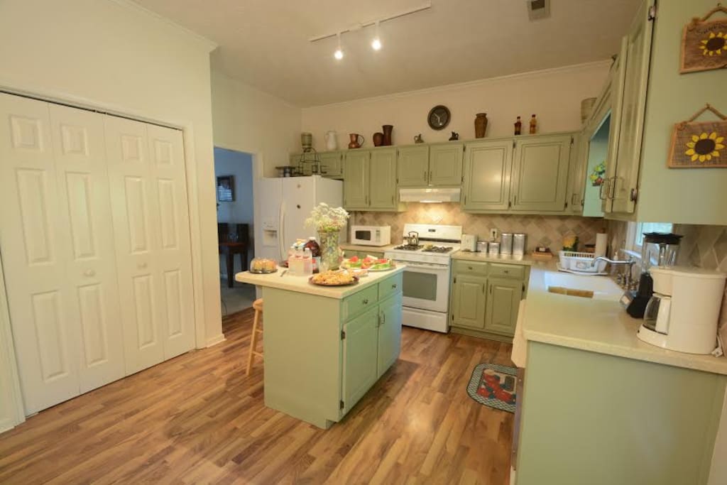 This Kitchen is bright and airy and has an island with stools for eating