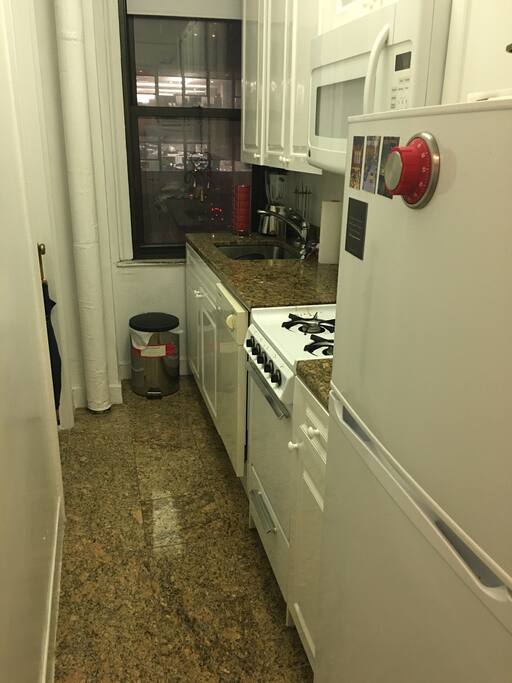 Kitchen with marble countertops, floors and modern appliances