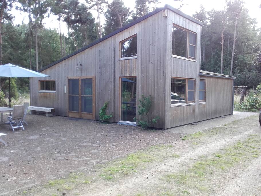 Zij-aanzicht met terras, tafel, stoelen en ligbed