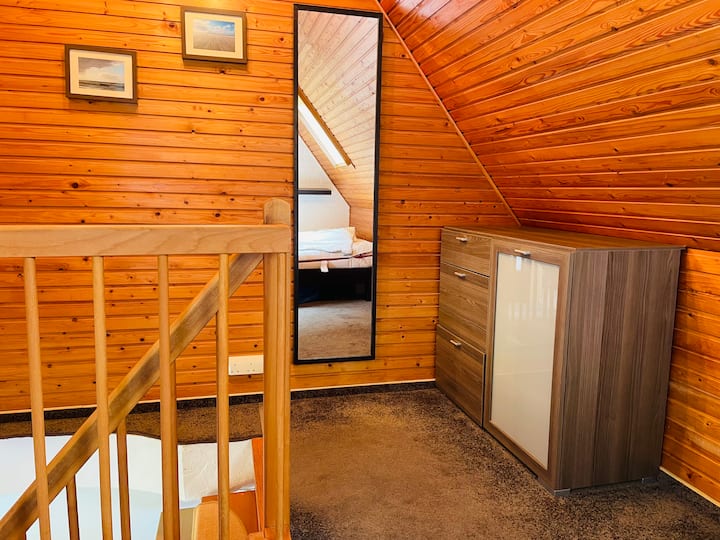 Des escaliers mènent à l'étage supérieur avec chambre et lit double 