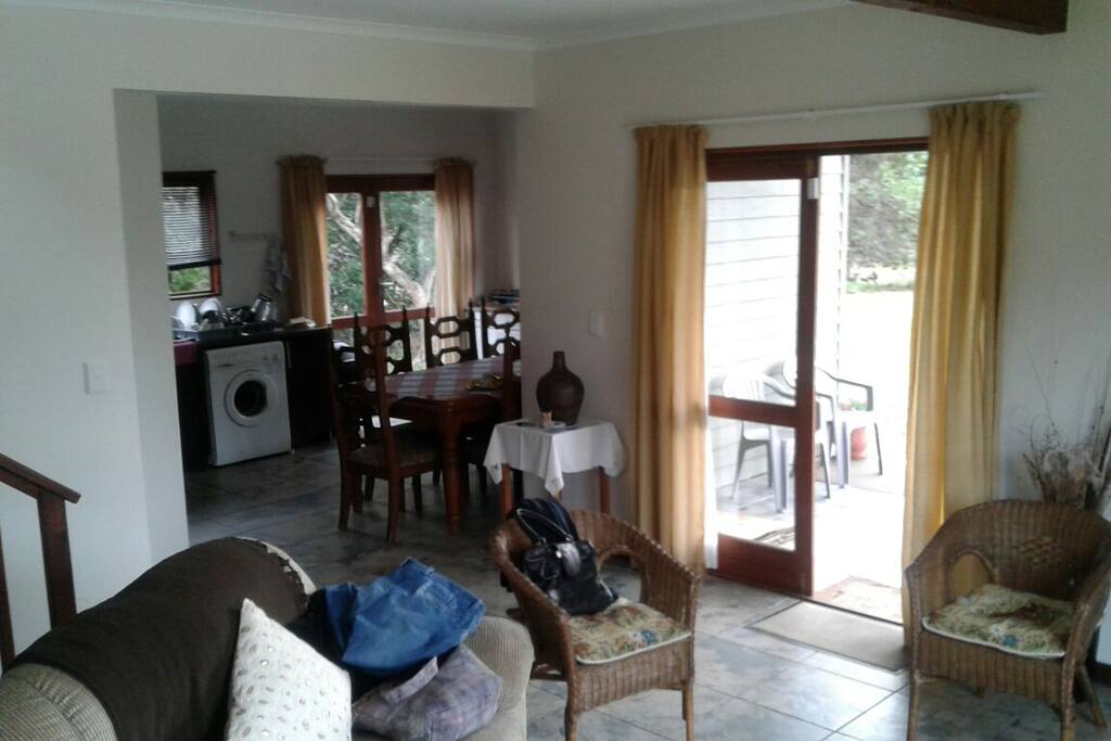 Open plan lounge with a tv and kitchen.