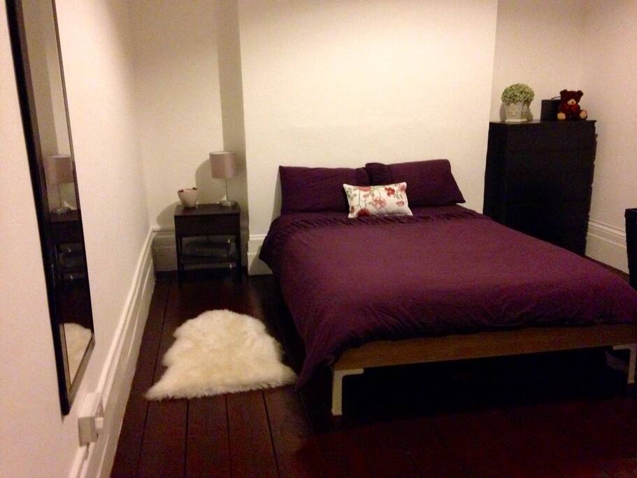 Beautiful and spacious bedroom with high ceiling and wooden floor