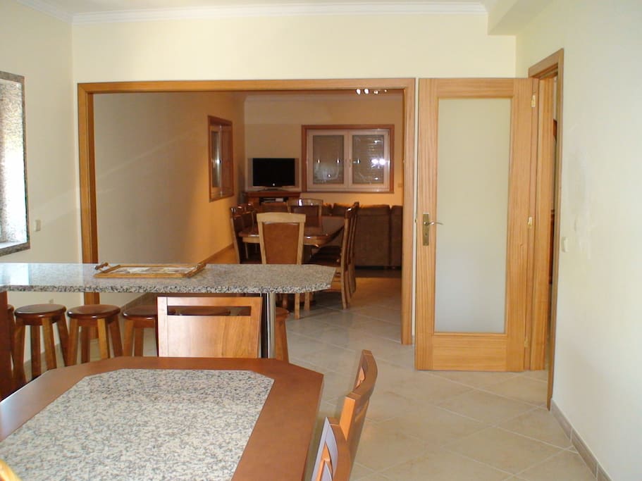 Full Kitchen with breakfast table and nook. Dining room and Tv room in the distance. Modern open plan design.