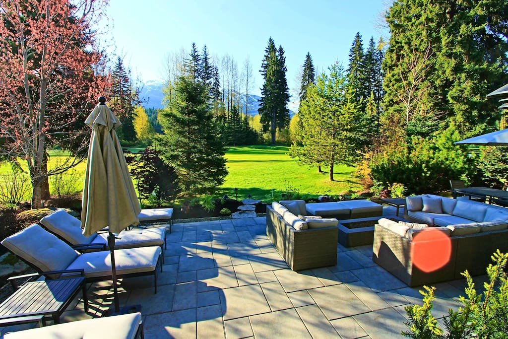 Backyard patio with firepit, sectional seating and chaise lounges