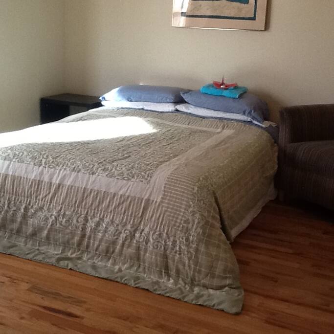A comfy bed and origami cranes welcome the new guests.