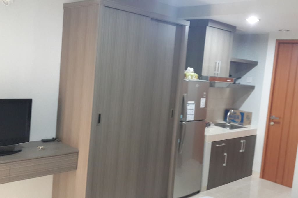 spacious closet alongside kitchen with full-sized fridge