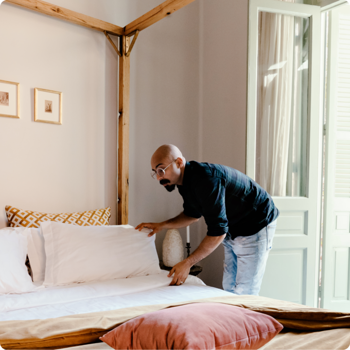 Man styling bed for photoshoot