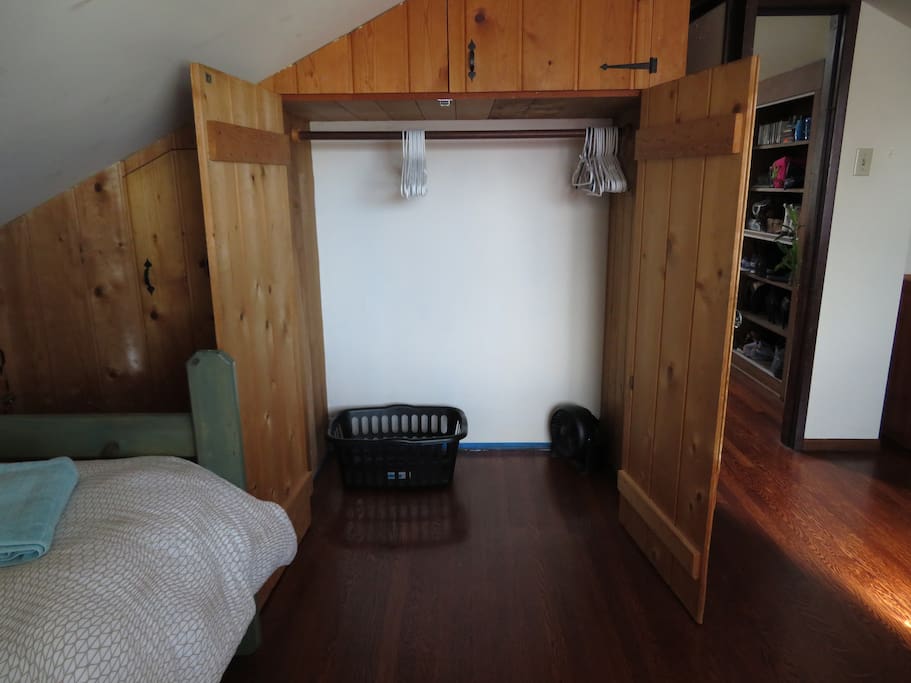 Closet with hangers, laundry basket, portable fan and space heater.