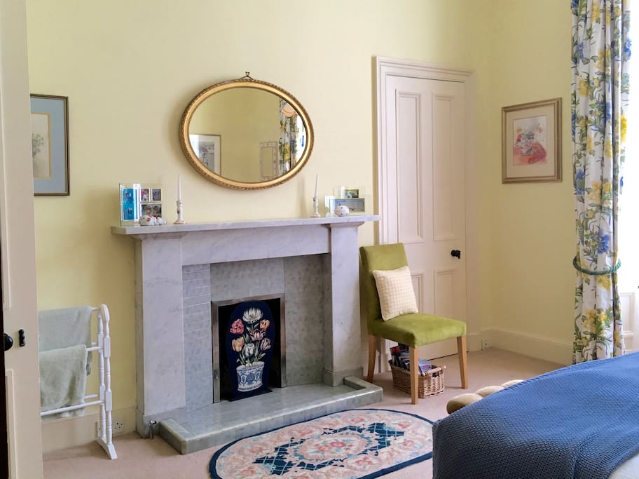 The room has traditional features such as a marble fireplace, gilt mirror and wall press.