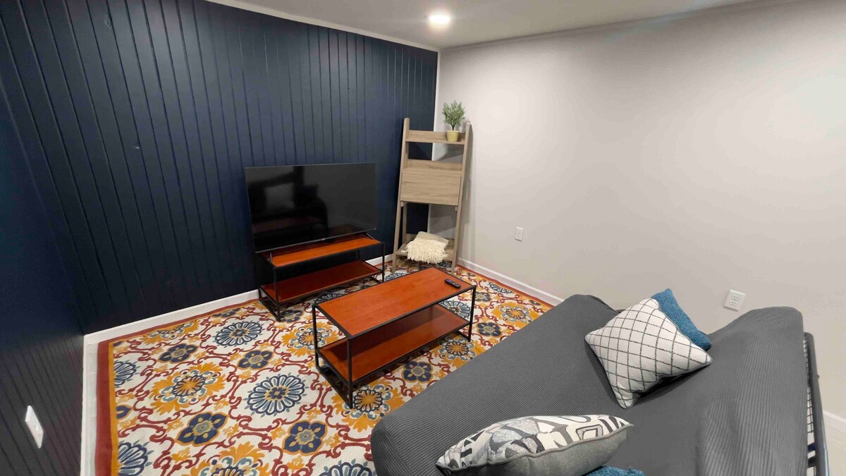 Beneden een woonkamer met 55-inch UHD-tv en uitklapbaar futonbed.  Perfect voor de extra gast of gamer in het gezin.