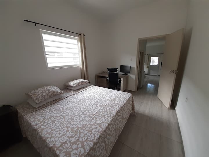 غرفة نوم كبيرة مع مكتب وسرير بمقاس كبير