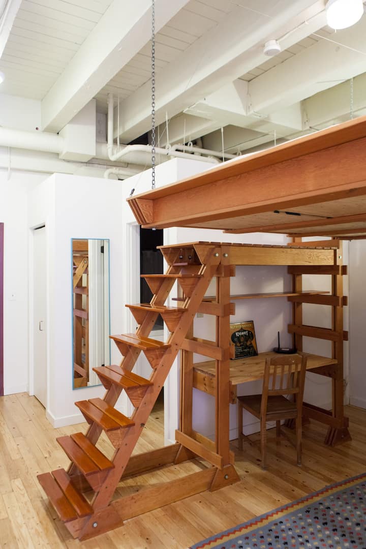 אזור חדר שינה עם מיטת קווין סייז ושולחן מובנה