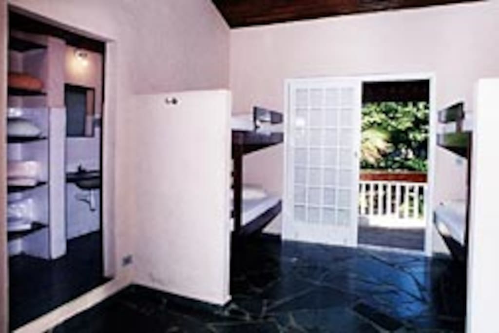 Quarto com duas beliches, banheiro e sacada pra frente da casa