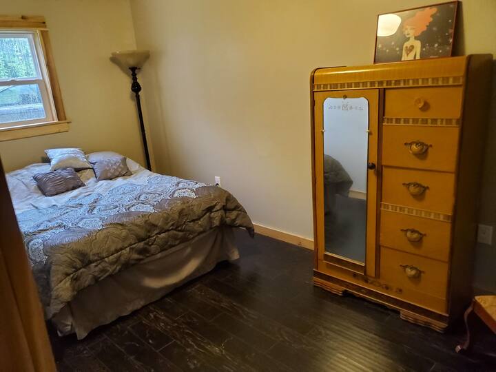 Back bedroom features a queen size bed and a lovely antique armoire.