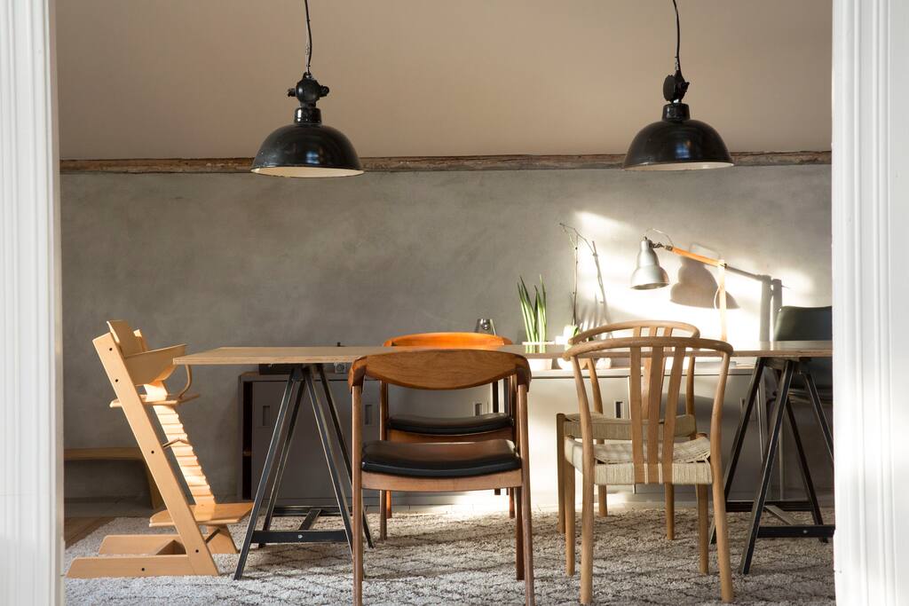 Cosy dining room with large plywood table, suitable for up to 8 people.