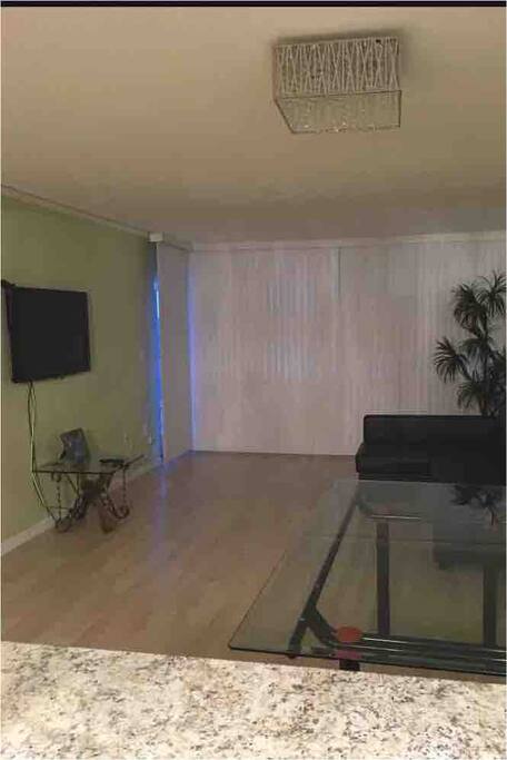 Living room with cable TV,glass table and reclinable couch.