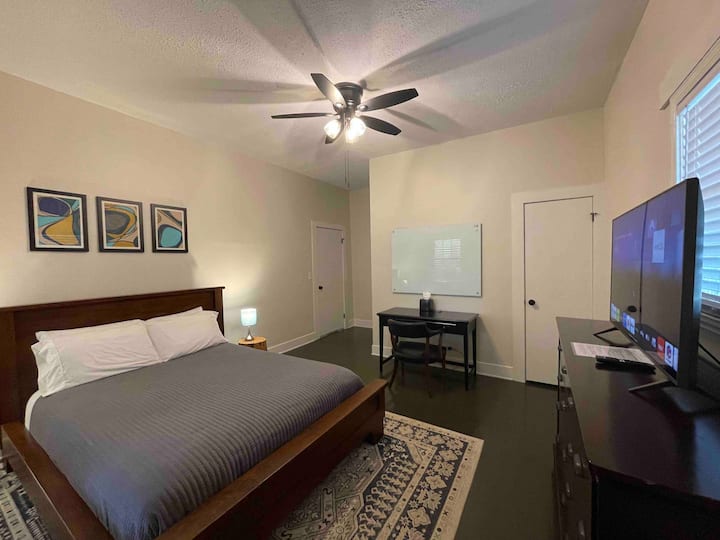 Queen size-säng med TV och skrivbord.