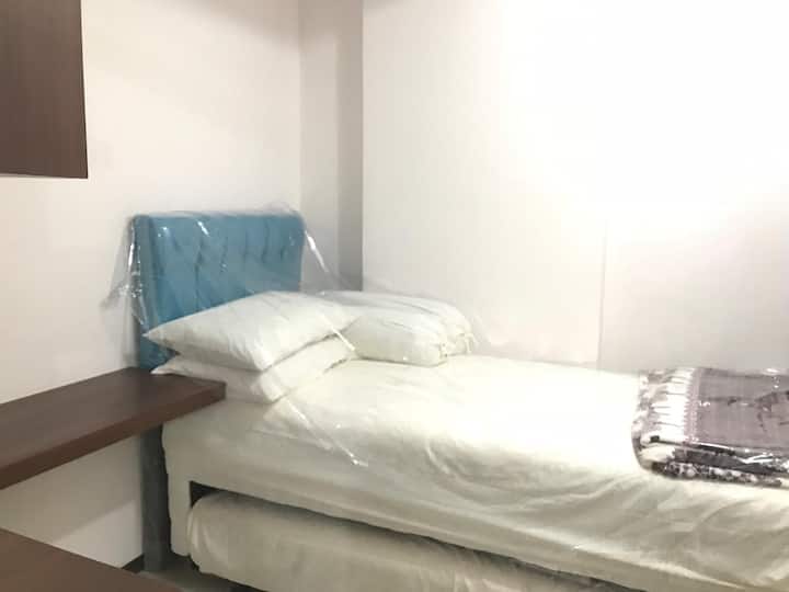 ห้องนอนขนาดเล็กพร้อมเตียงเดี่ยวที่ใช้งานได้ 2 หลัง