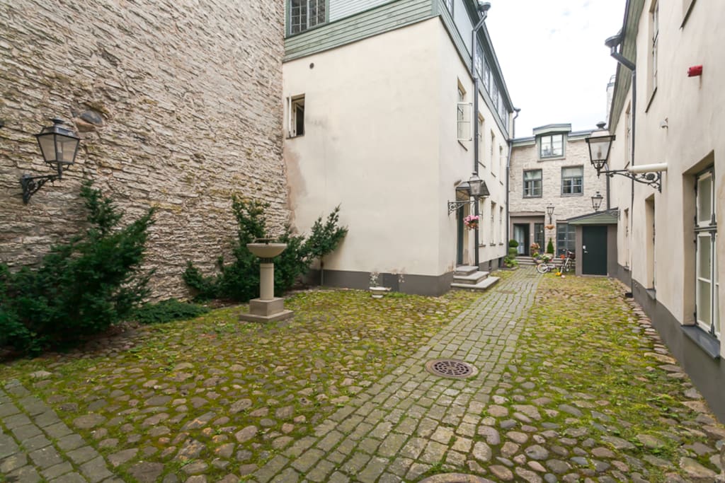 In the inner yard a fountain and the medieval city wall greet the guest.