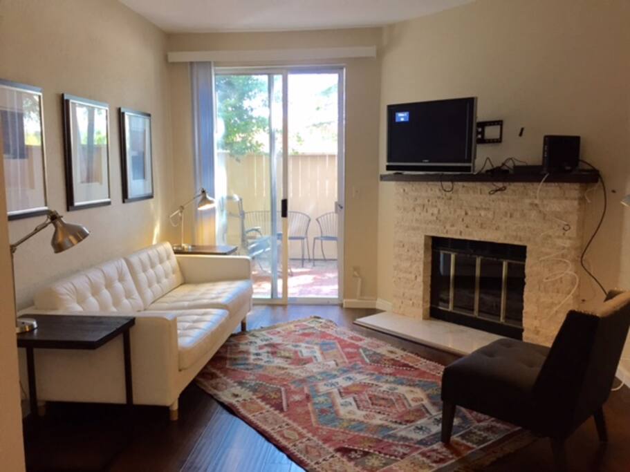 Living Room with view to patio, TV over fireplace, leather sofa & side chair