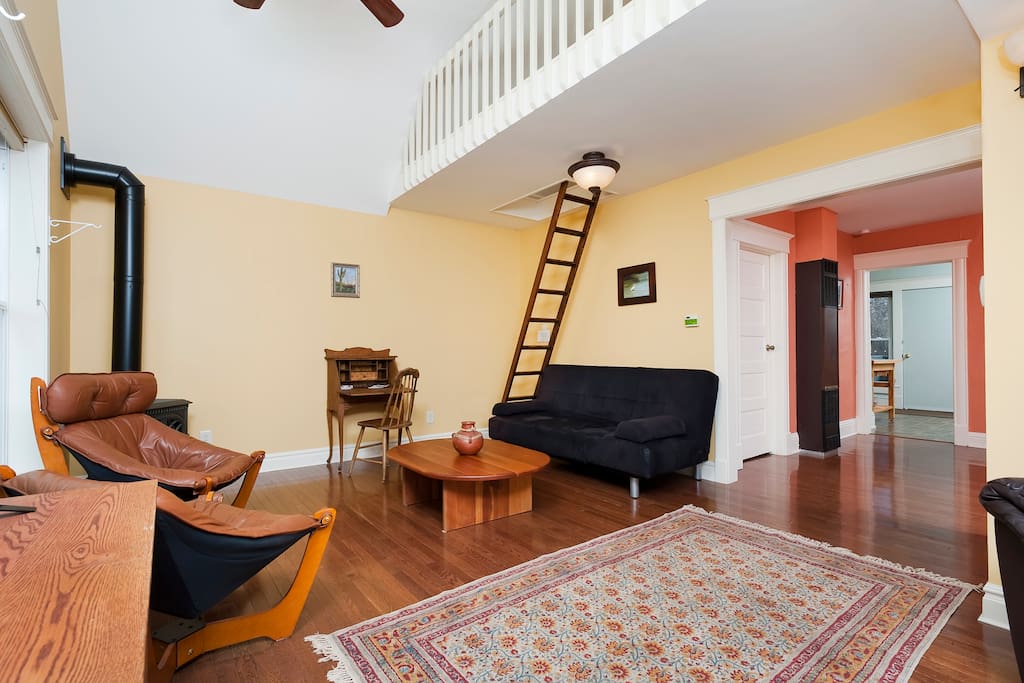 Living room with ladder up to loft.
