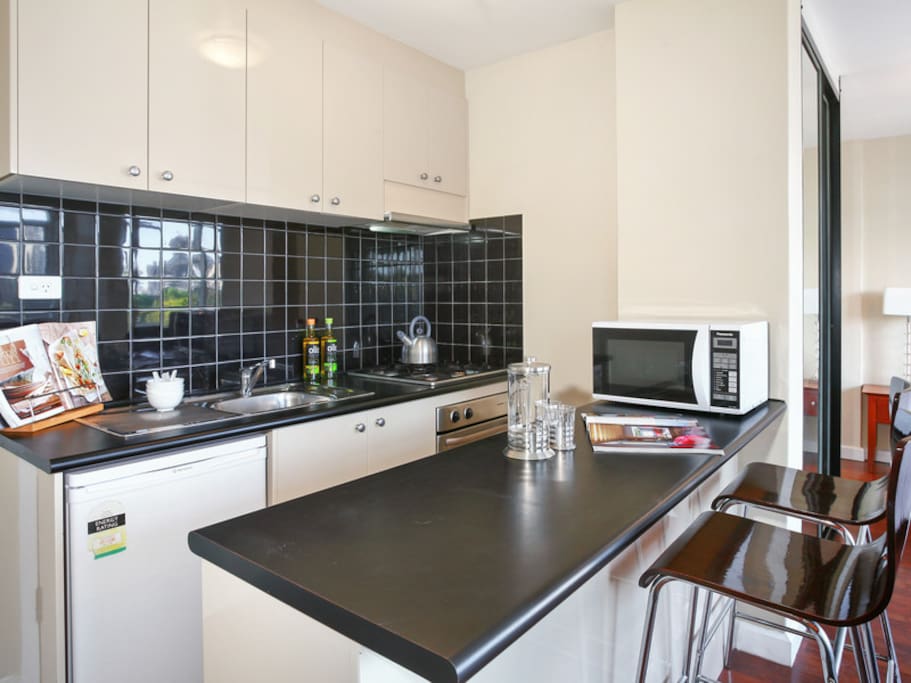 Sleek kitchen with gas range, oven, microwave and fridge