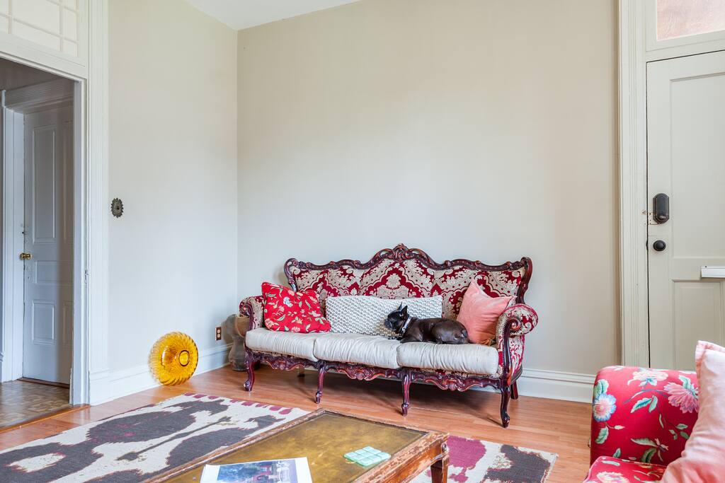 Living room: Vintage sofa & couch. Lots of glass art & mismatched rugs.