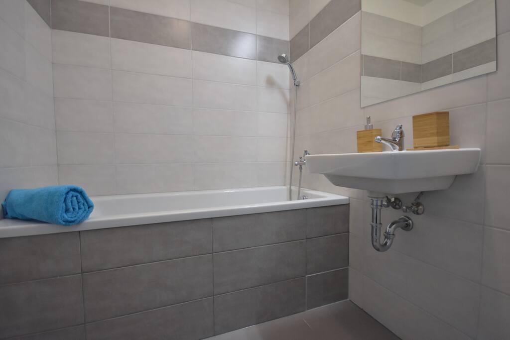 A spacious bathroom with washing maschine.