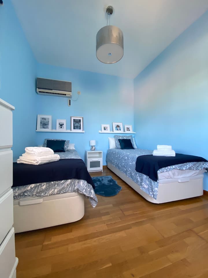 Chambre bleue avec deux lits de 90x200, une commode et petite terrasse
