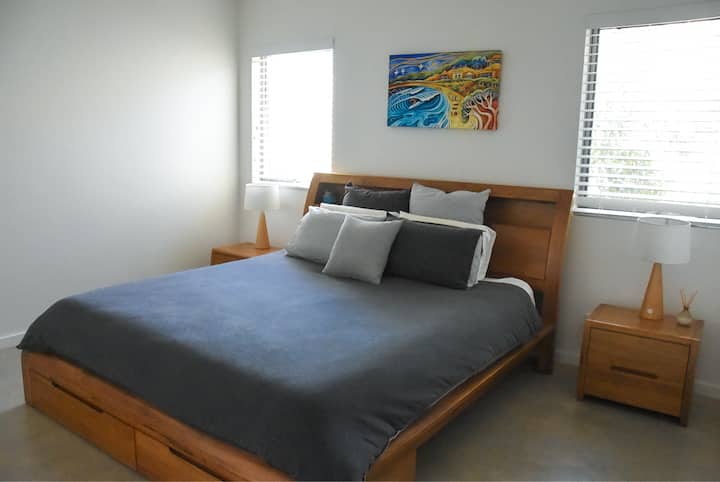 חדר שינה ראשי עם מיטת קינג סייז וחדר רחצה צמוד