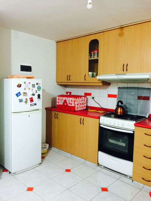 Cocina con refrigeradora y horno microondas.