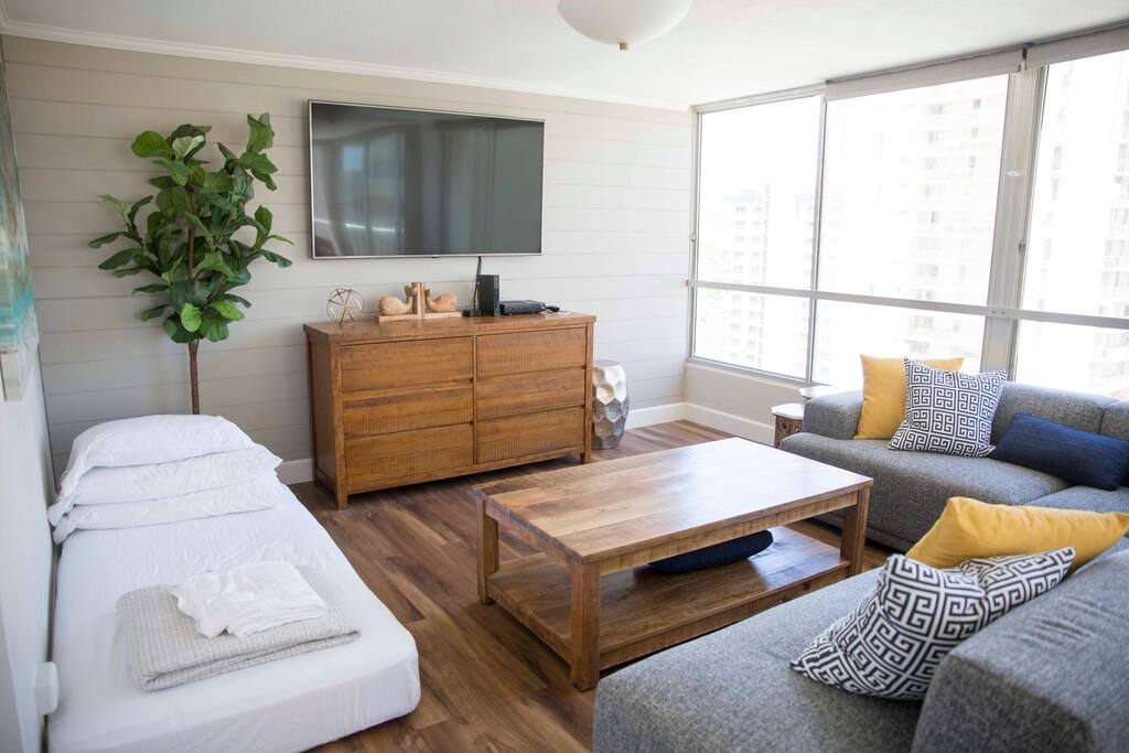 Living room with 65 inch internet connected TV showing how another twin bed can be set up.