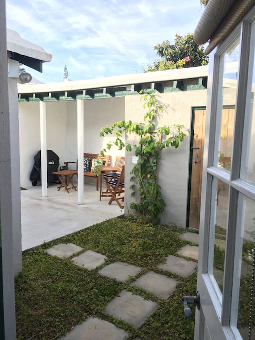 The private patio just outside the back door featuring new furnishings and a gas Weber grille. The laundry room is inside the wood door you see on the right.