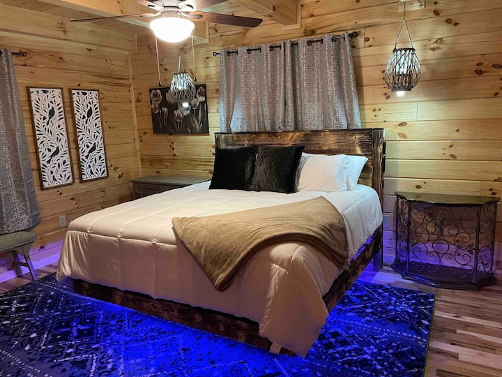 Master bedroom! (Aka The Stallion Room) King size floating bed w/ multi-color LED lights Underneath w/ hanging multi color lights on both sides of the bed! 40” Vizio Smart TV w/ electric Fireplace and full attached bathroom!