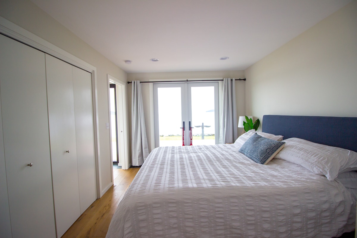 Главна спална соба со извонреден поглед на вода и приватна бања.