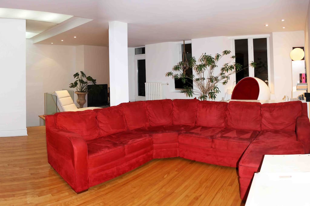 Living room area : huge couch, TV integrated in wall
