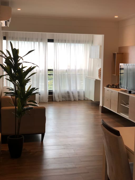 Sala ampla com Tv, sofá, barzinho e uma linda vista de Salvador.
