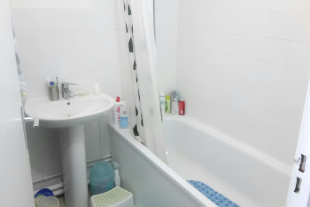 Une salle de bain refaite à neuf baignoire et lavabo. WC séparés