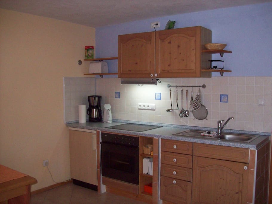 In der Küchenzeile finden Sie Kühlschrank, Cerankochfeld und Backrohr, Kaffeemaschine, Wasserkocher und Toaster sowie Ess- und Kochgeschirr