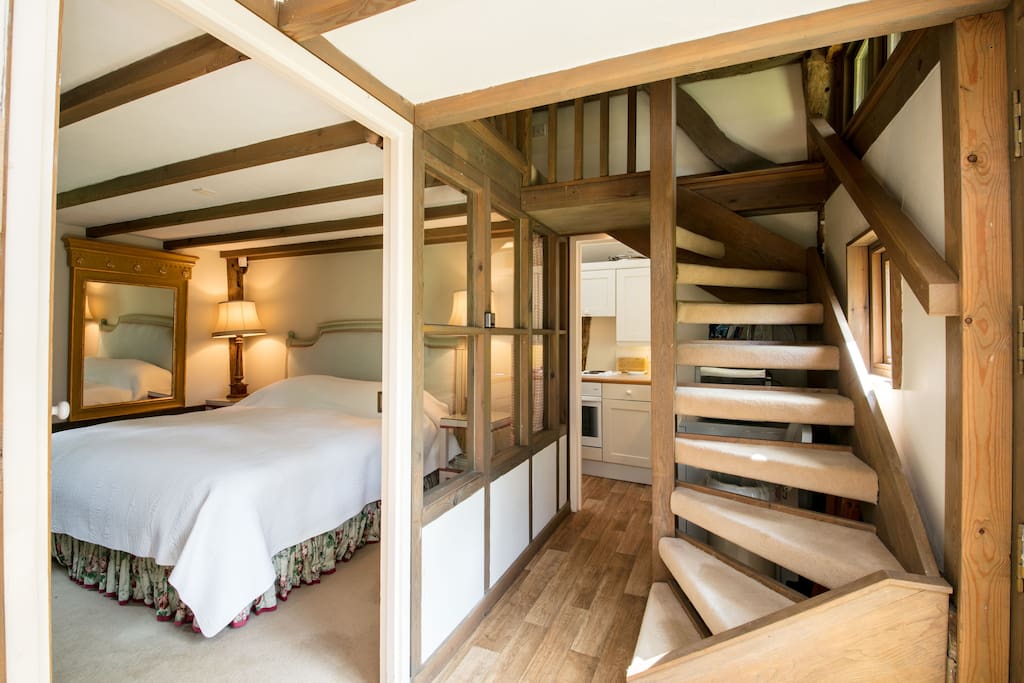 Double bed and stairs going up to open plan bedroom