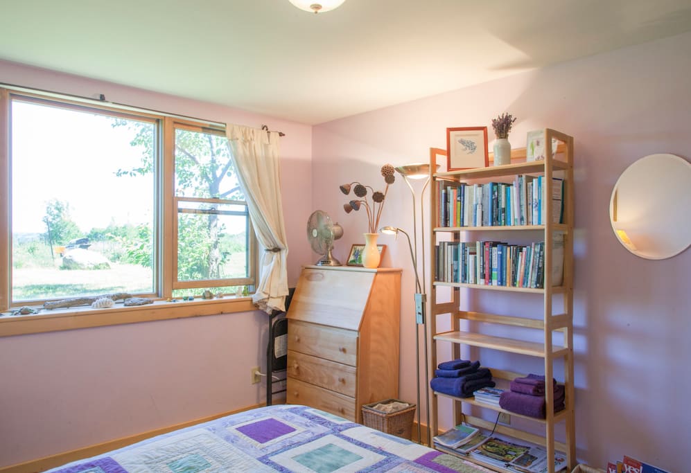 A desk/dresser and bookcase full of local magazines, resources, and ecologically-minded books are features of the Lavender Room.