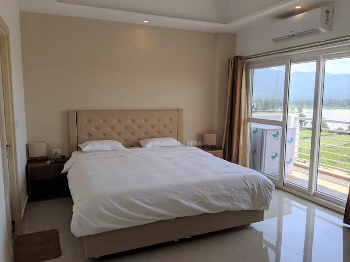 Master bedroom with view of Ganges and access to balcony