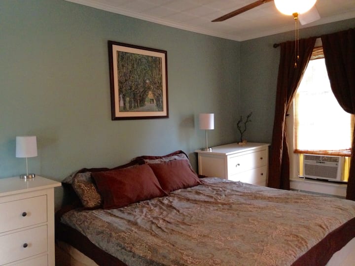 The master bedroom offers a king-sized bed with a window air-conditioning unit.
