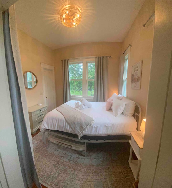 Dormitorio queen con ventilador de luz de techo. El aire acondicionado de la ventana se instaló a mediados de junio y se retira a finales de septiembre. La mini cómoda se puede mover al armario y se puede colocar una cuna plegable (debajo de la cama) allí. 